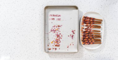 Düz yatıyordu. Çubuk krakerleri erimiş çikolataya batırıp Cadılar Bayramı 'nda çikolata kaplı çubuk kraker yapmak..