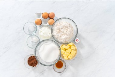 Düz yatıyordu. Kadife kek ve krem peynirli kek pişirmek için bardaktaki ölçülü malzemeler..