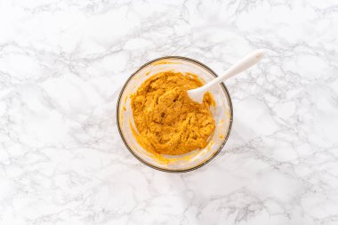 Düz yatıyordu. Büyük bir bardakta karışımı karıştırarak çikolatalı kabaklı kek ve karamel karışımı..