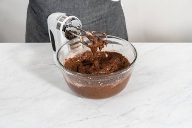 Kırmızı kadife kek ve krem peynir jöleli kek yapmak için büyük bir bardakta karıştırma malzemesi..