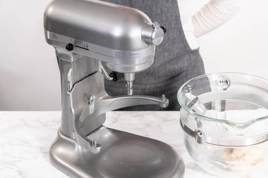 Büyük bir bardaktaki malzemeleri karıştırıyorum. Pizza hamuruyla karıştırıyorum..