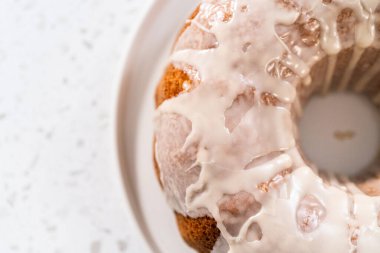 Taze pişmiş basit vanilyalı kek servis tabağında beyaz jöleli.