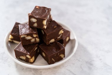 Beyaz bir tabakta ev yapımı çikolatalı macadamia şekerlemesi..