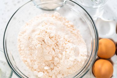 Kutu kekten basit bir vanilyalı kek pişirmek için cam karışımında ölçülmüş malzemeler..