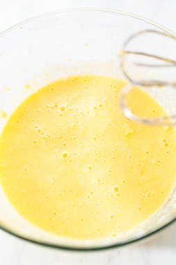 Kırmızı kadife kek ve krem peynir jöleli kek yapmak için büyük bir bardakta karıştırma malzemesi..