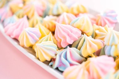 Beyaz servis tabağında çok renkli tek boynuzlu at kurabiyeleri..