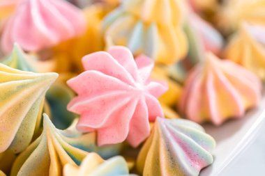 Beyaz servis tabağında çok renkli tek boynuzlu at kurabiyeleri..