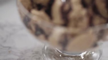 Manzarayı kapat. Ev yapımı çikolatalı dondurma, cam bir dondurma kasesinde çikolatayla süslenmiş..