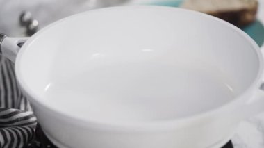 Manzarayı kapat. Beyaz tavada taze yumurta kızartıyorlar..