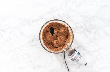 Düz yatıyordu. Büyük bir bardakta ıslak malzemeler karıştırarak kırmızı kadife kekler ve beyaz çikolatalı ganache kreması pişiriyorum..