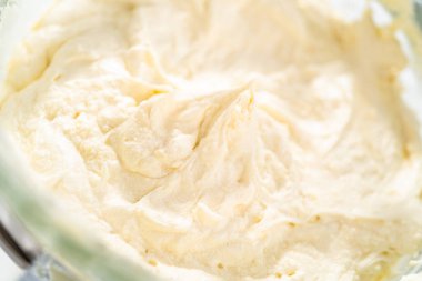 Beyaz çikolatalı ganache yapmak için mutfak mikserinde beyaz ganache çırpmak..