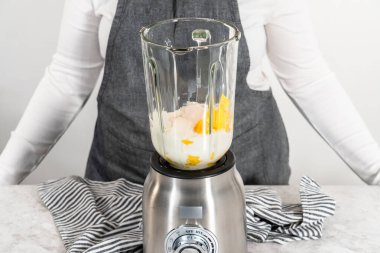 Mutfak blendırında mango boba smoothie hazırlamak için malzemeler karıştırılıyor.