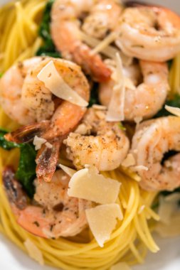 Beyaz seramik kaselerde ıspanaklı sarımsaklı karides makarnası servis ediyorum..