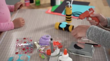 Close up view. Kids papercraft. Making paper bugs out of the empty toilet paper rolls and construction paper.