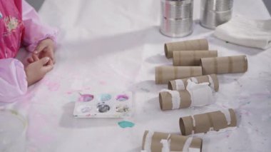 Close up view. Kids papercraft. Making paper bugs out of the empty toilet paper rolls and construction paper.