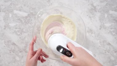 Düz yatıyordu. Vanilyalı kremanın içine pembe gıda boyası karıştırarak funfettti desenli pastayı süslemek için..