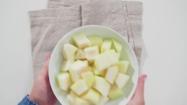 平躺在床上在一个白碗里切成片的金瓜果 — 图库视频影像
