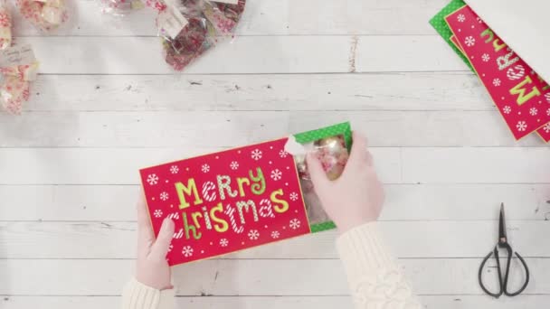 平躺在床上一步一步 把自制的软糖和饼干装进圣诞礼品盒 — 图库视频影像