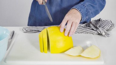 Adım adım. Beyaz kesme tahtasında kaygan altın çiğ taneli kavun.