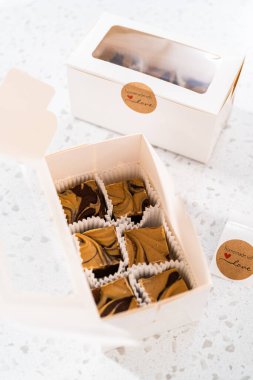 Fıstık ezmeli ev yapımı çikolatalı şekerlemeler beyaz bir hediye kutusuna konuyor..