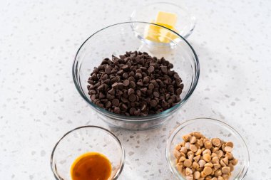 Fıstık ezmeli çikolata yapmak için cam karışımında ölçülü malzemeler..