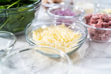 Ispanak ve jambonlu frittata hazırlamak için cam karıştırma kabındaki malzemeler..