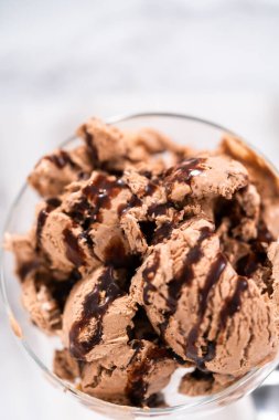 Ev yapımı çikolata parçalı dondurmayı cam bir kasede çikolatayla servis ediyorum..