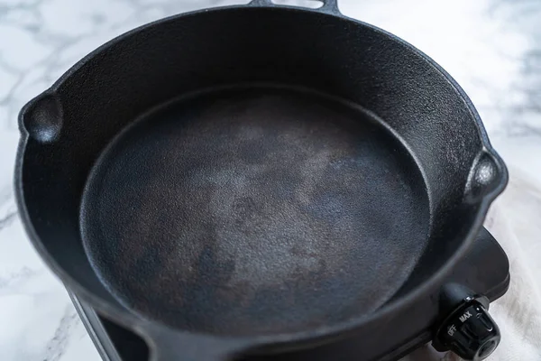 在炉子上加热铸铁锅 准备菠菜和火腿煎饼 — 图库照片