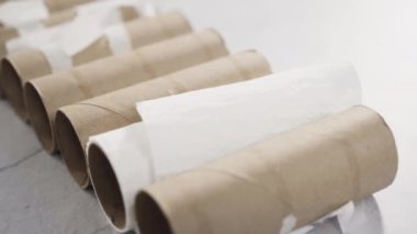 Gri arkaplanda boş tuvalet kağıdı ruloları kullanılıyor.