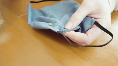 Koronavirüs salgını için dikiş makinesiyle pamuk yüz maskesi dikiyorum..