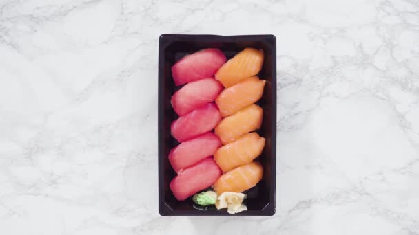 平躺在床上预先包装的各种寿司和寿司卷在一个塑料盘子里 — 图库视频影像