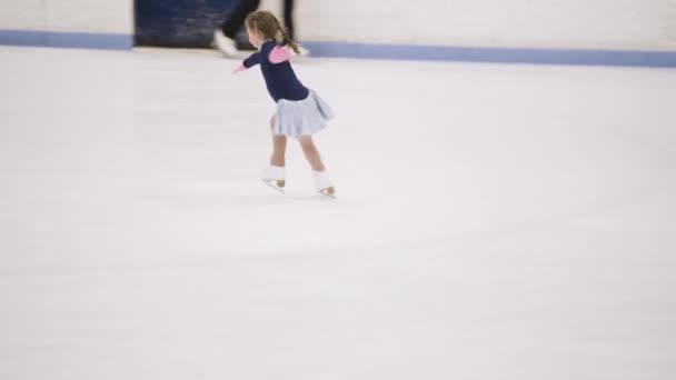 小さな女の子練習フィギュアスケート上の屋内アイススケートリンク — ストック動画