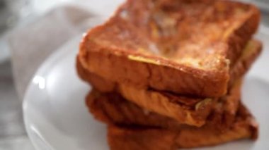 Çilek ezmesi ve pudra şekeriyle süslenmiş taze yapılmış Fransız tostu yığını..