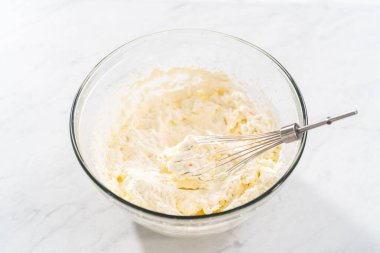 Ev yapımı krem şantiyi hazırlamak için cam bir karıştırma kabında malzemeleri karıştırıyorum..