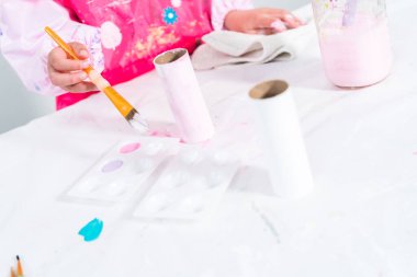 Tuvalet kağıdından tek boynuzlu at yapan küçük bir kız..