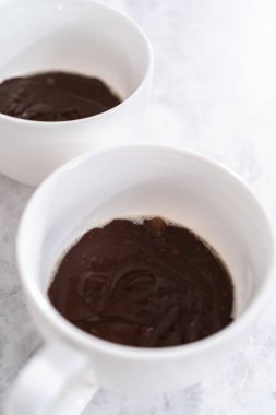 Beyaz bardaklarda çikolatalı kek hamuru pişmeye hazır..