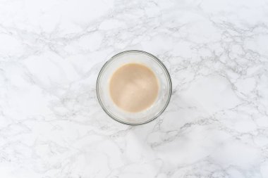 Düz yatıyordu. Limon jöleli. Limon jölesi yapmak için malzemeleri cam bir kapta çırpma kabıyla karıştırıyorum..