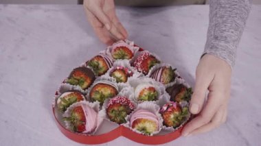 Adım adım. Çikolata soslu çilekli kalp şeklinde bir kutu..