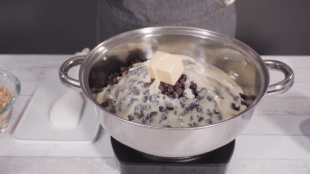 一歩ずつ マカダミアナッツファッジを作るために調理鍋にチョコレートチップを溶かす — ストック動画