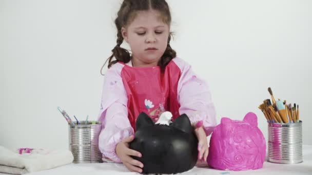 小さな女の子はハロウィンのためのアクリル絵具でカボチャをペイント — ストック動画