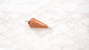 Düz yatıyordu. Adım adım. Çukulatalı ganache şekerli ve metal uçlu..