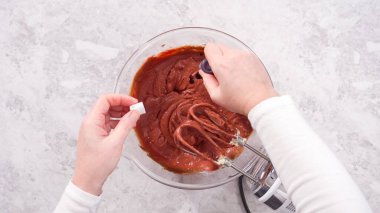 Düz yatıyordu. Adım adım. Kırmızı kadife kek hazırlamak için karıştırma kabındaki malzemeleri karıştırıyorum..