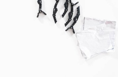 Düz yatıyordu. Saç tokaları ve folyo çarşaflar beyaz arka planda ölen saçlar için..