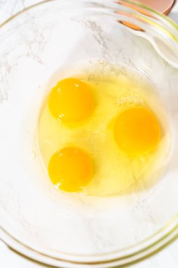 Küçük Paskalya ekmeği pişirmek için ıslak malzemeleri büyük bir bardakta karıştırıyorum..