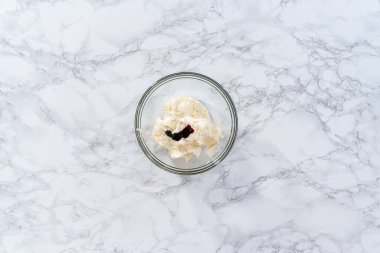 Düz yatıyordu. Marketten alınmış vanilyalı kremanın içine besin renkleriyle karıştırılmış..