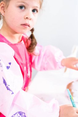 Küçük kız COVID-19 salgınında evde uzaktan öğrenim için sanat projesi üzerinde çalışıyor..