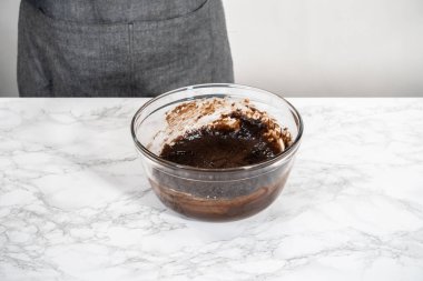 Büyük bir bardaktaki malzemeleri karıştırarak naneli çikolatalı kekler pişiriyorum..