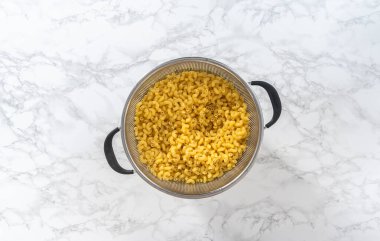 Düz yatıyordu. Makarna ve peynirli brokoli hazırlamak için kaynamış dirsek makarnası..