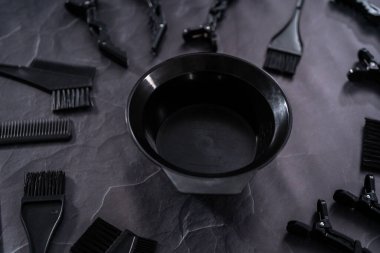 Siyah saç rengi boya seti ve siyah arka planda karıştırma kabı..