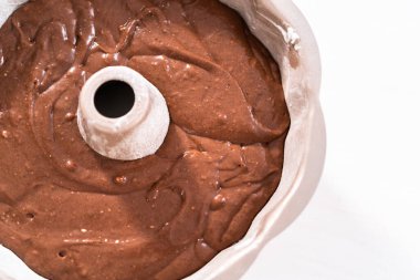 Chocolate cake batter in a metal bundt cake pan ready for baking. clipart